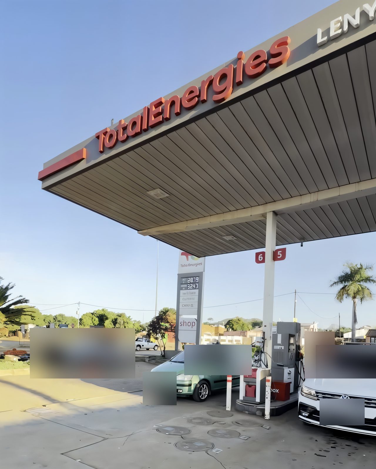 Cars at pumps 5 and 6 under the TotalEnergies canopy, number plates and people blurred